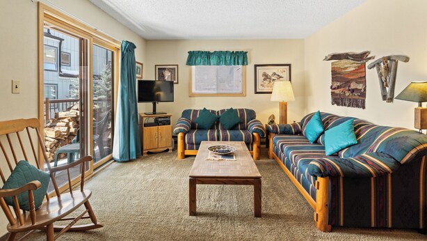 A cozy living room with a sofa, a rocking chair, a coffee table, and a TV. - Sdc204a-1 (Keystone)