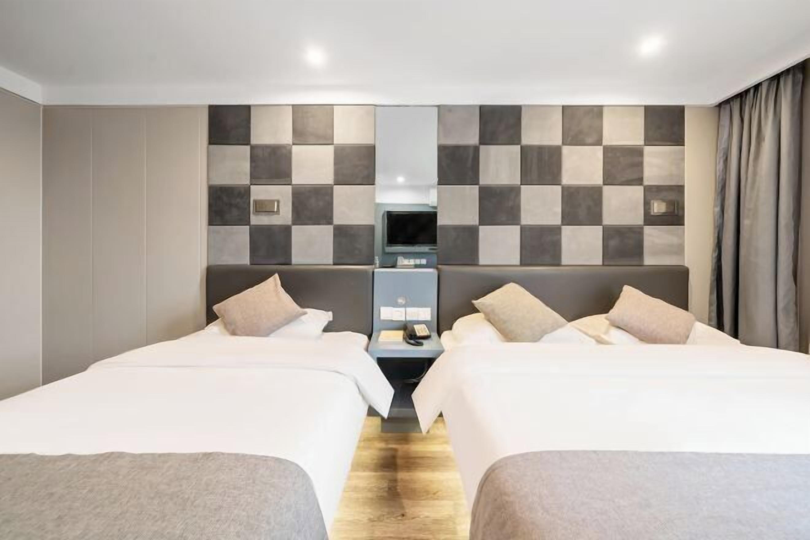 Una habitación de hotel con dos camas, televisión y minibar.