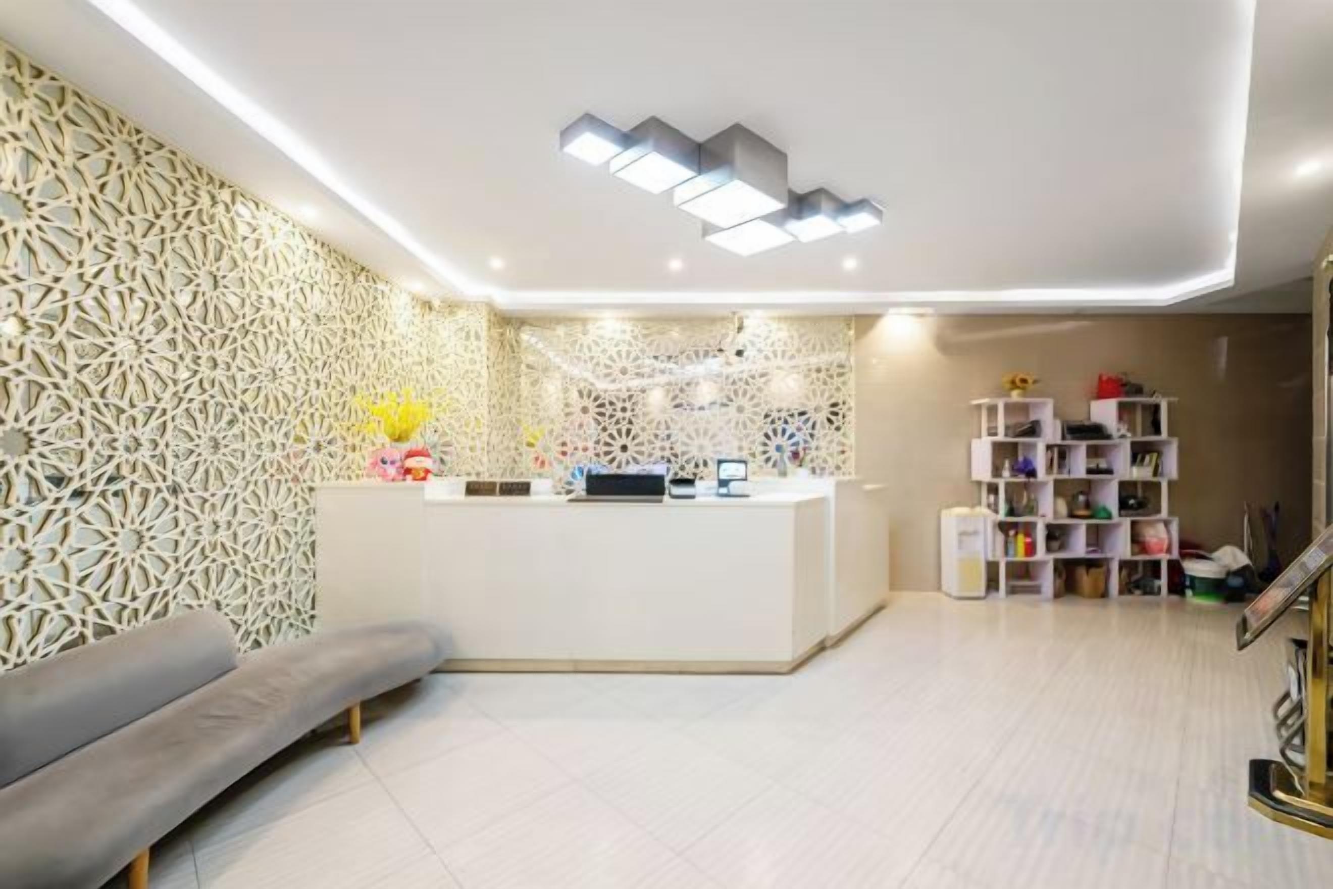 A reception area with a reception desk, a sofa, and a bookshelf.