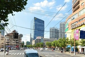 A city street with buildings, vehicles, and pedestrians.