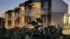 Un edificio moderno de varios pisos con techo plano, ventanas amplias y una escalera que conduce a los niveles superiores.