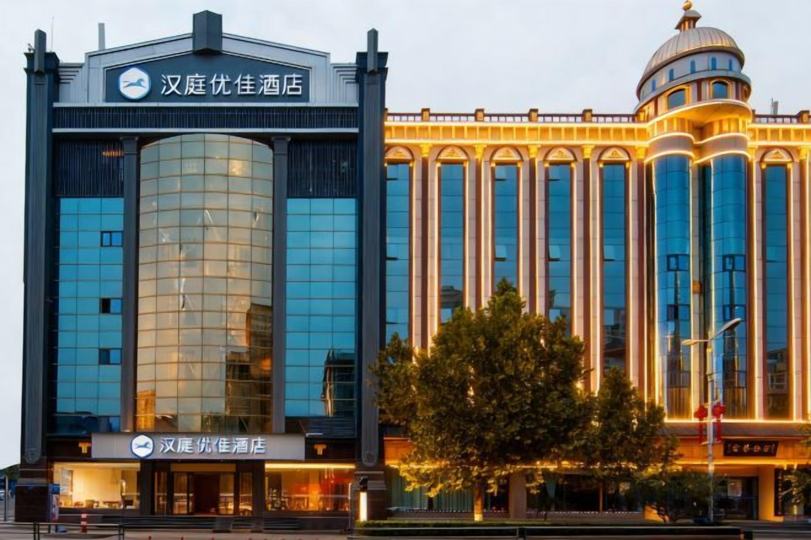 A hotel with a modern facade, large windows, and a prominent dome structure.