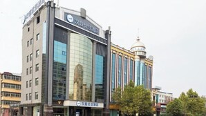 A modern hotel with a prominent glass facade and a traditional tower structure. - HanTing Premium Hotel (Linfen Gulou West Street Ancient City Wall) (Linfen)
