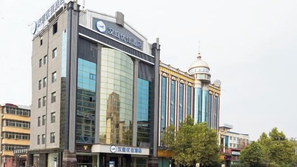 Un hotel moderno con una fachada de vidrio destacada y una estructura de torre tradicional.