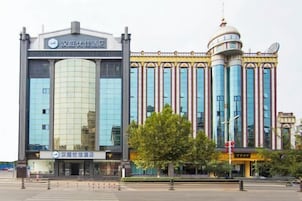 Un hotel moderno con una fachada de vidrio destacada, una estructura en forma de cúpula y un estilo arquitectónico tradicional.