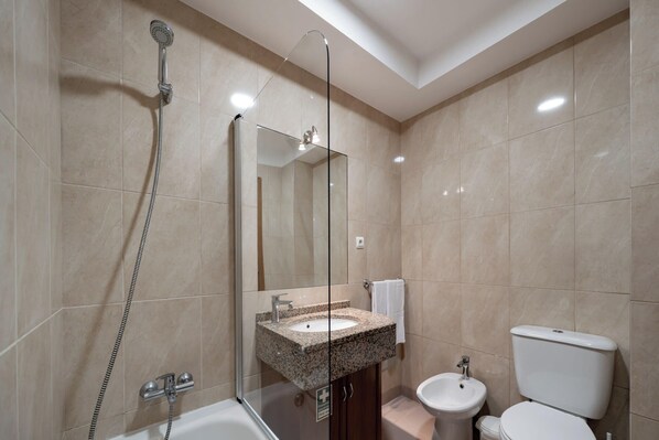 A modern bathroom with a glass-enclosed shower, a sink with a vanity, and a toilet.