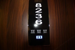 A digital elevator display with floor numbers 8, 2, 3, 6, and a button for "Please wait" in a hotel setting. - Shanghai Xiangyu Business Hotel (Shanghai)