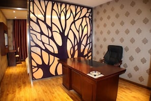 Ein Holztisch in einem Raum mit ornamentalem Wandpapier und einer dekorativen Baumwand.