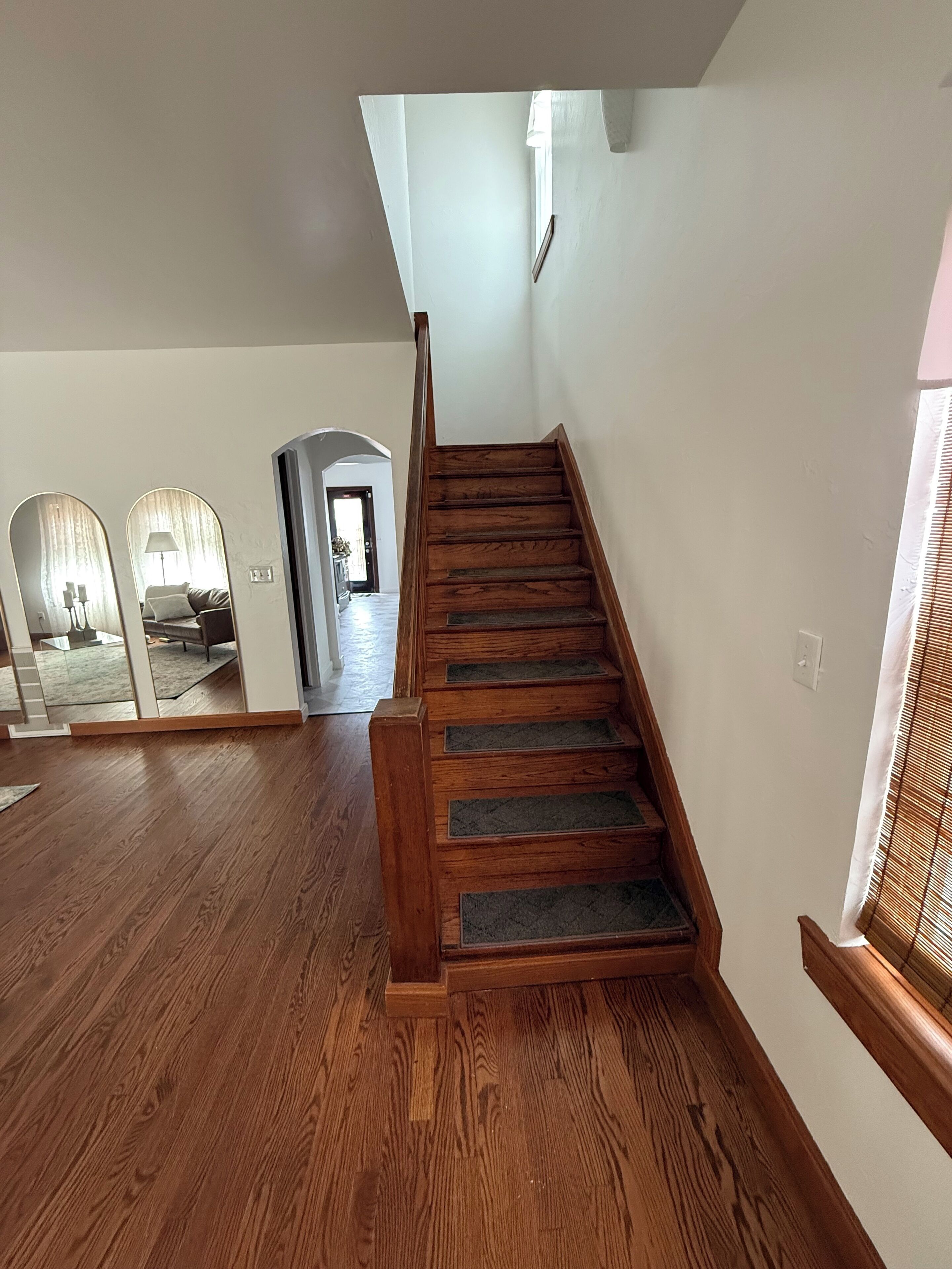 A wooden staircase with a handrail leading to a landing.