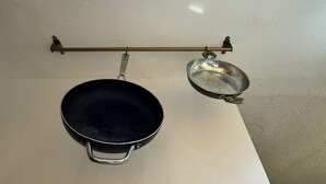 A kitchen with a hanging pot rack holding two pots. - Waterfront Condo with Fishing, Paddleboard, and yard access. (North Miami)
