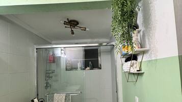 A bathroom with a shower, toilet, and a towel rack.