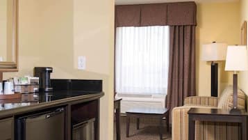 Une chambre d’hôtel équipée d’une kitchenette, d’un coin repas, d’un canapé et d’une lampe.