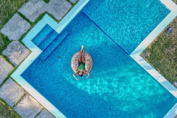 Aerial pool view → Where blue waters whisper calm dreams