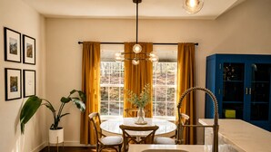A kitchen with a dining table, chairs, a chandelier, a sink, and a blue cabinet. - Modern Farmhouse Retreat Minutes to Tryon International + Wineries (Rutherfordton)