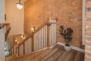 Staircase leads to an upper level with a potted plant below.