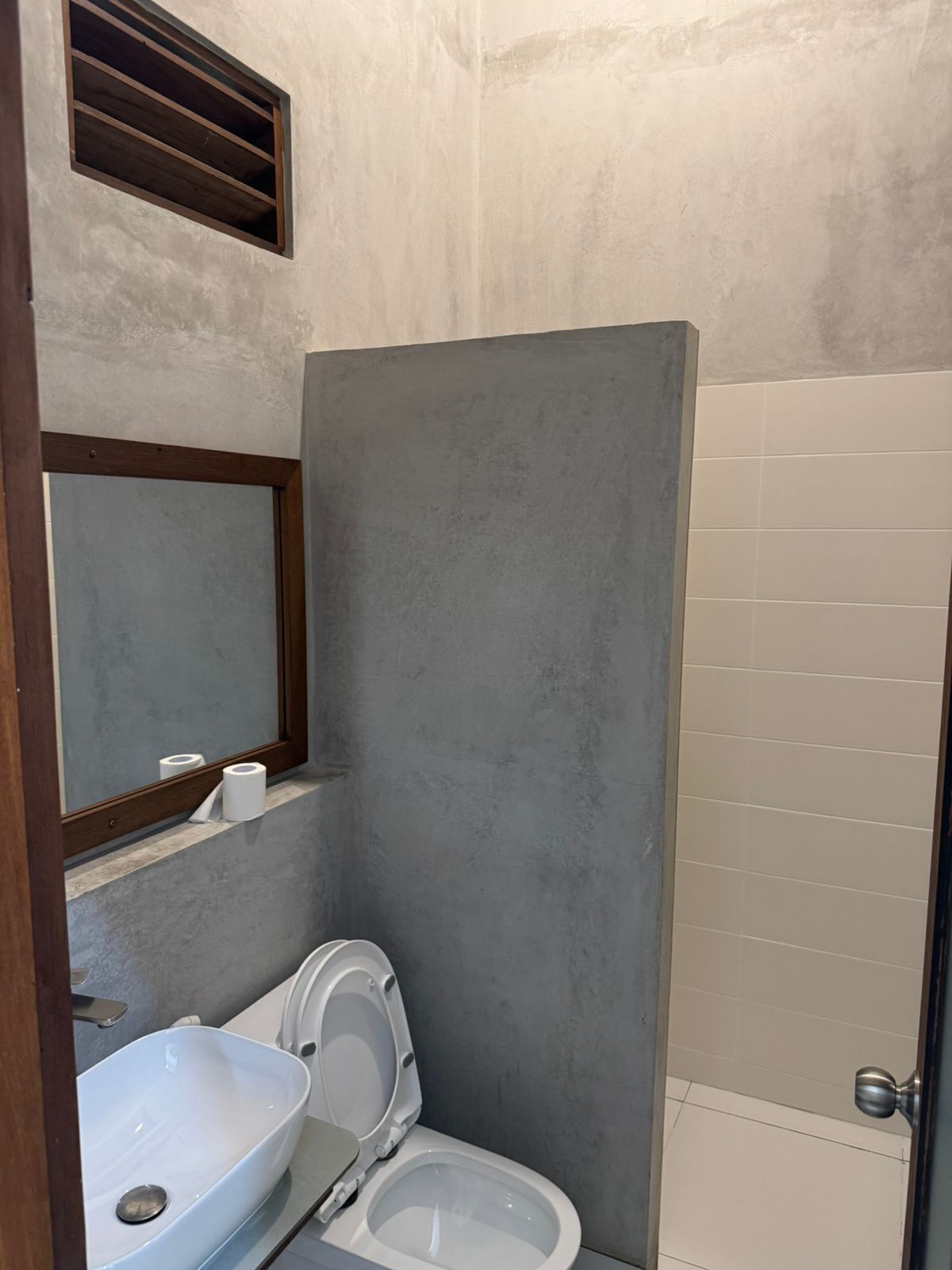 Une salle de bain avec des toilettes, un lavabo et un miroir.
