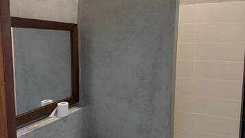 Une salle de bain avec des toilettes, un lavabo et un miroir.