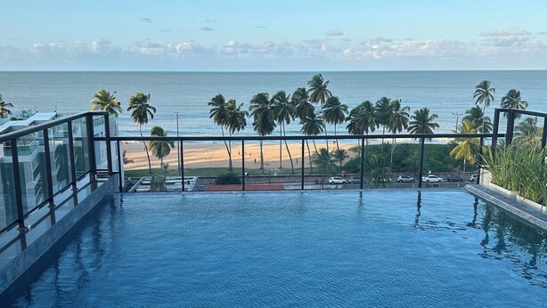 Une piscine avec vue sur la plage et l’océan.