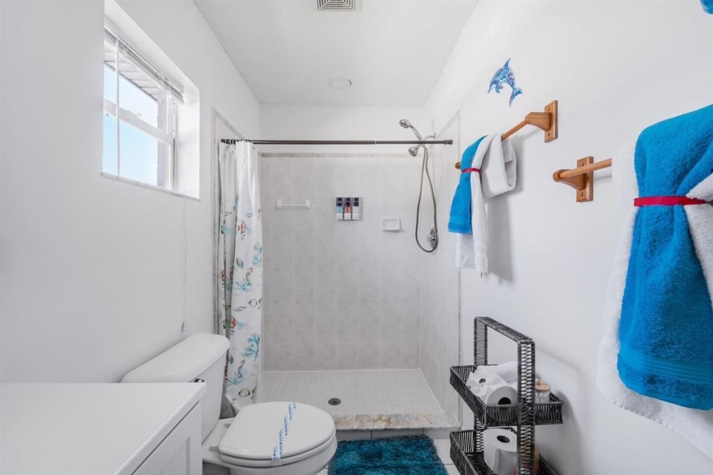 A compact bathroom with a shower, toilet, and towel rack.