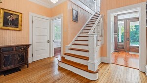 Eine Treppe mit weißen Spindeln und Holzdielen, die zu einer zweiten Etage führt.