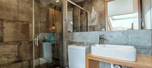 Une salle de bain avec une douche à parois de verre, un lavabo blanc et un miroir.