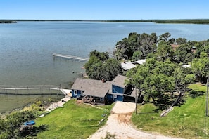 A lakeside property with a dock, a house, and a grassy area.
