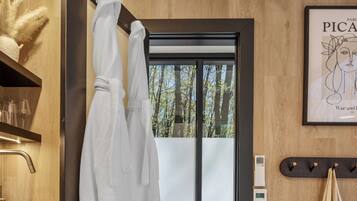 Un bagno moderno con una parete in legno, una porta doccia in vetro e un'opera d'arte di Picasso incorniciata.