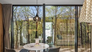 A modern dining area with a round table, two chairs, and a pendant light. - Mirror Villas - Modern Retreat with private hot tubs and mountain view (Mercersburg)