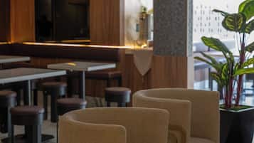 Un interior moderno con arreglos de asientos y una zona de bar.