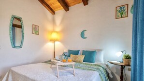 A bedroom with a bed, bedside table, lamp, and decorative items. - Air-conditioned apartment a few meters from the sea of ​​about 40 square meters characterized by simple and functional furnishings, located on the first floor and composed of a living room with kitchenette and sofa bed, a bedroom with double bed, bat (Golfo Aranci)