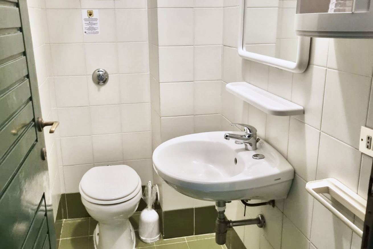 Ein Badezimmer mit Toilette, Waschbecken und Handtuchhalter.