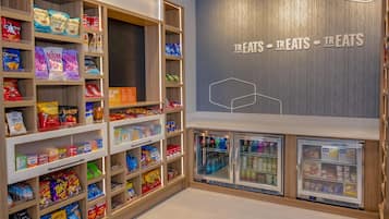 A snack and beverage section with shelves stocked with various snacks and drinks, and two refrigerated display cases.