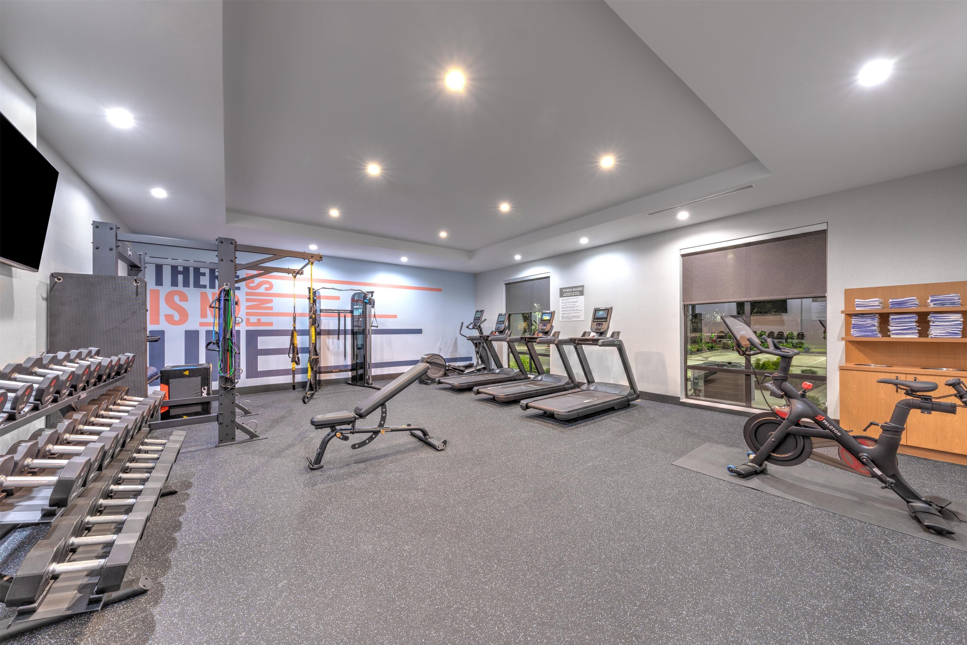A gym with treadmills, a stationary bike, and weight machines.