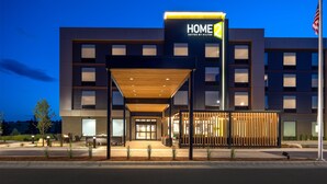 Ein modernes Hotel mit einem gut sichtbaren Schild, auf dem "HOME 2 SUITES BY HILTON" steht.