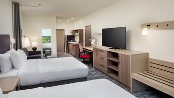 Une chambre d’hôtel avec deux lits, un bureau, une télévision et une vue sur l’extérieur.