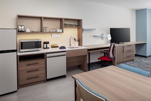 A compact hotel room with a kitchenette, a dining area, and a TV. - Home2 Suites By Hilton St. Joseph (St. Joseph)