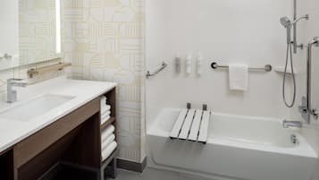 A modern bathroom with two sinks, a shower, and a towel rack.