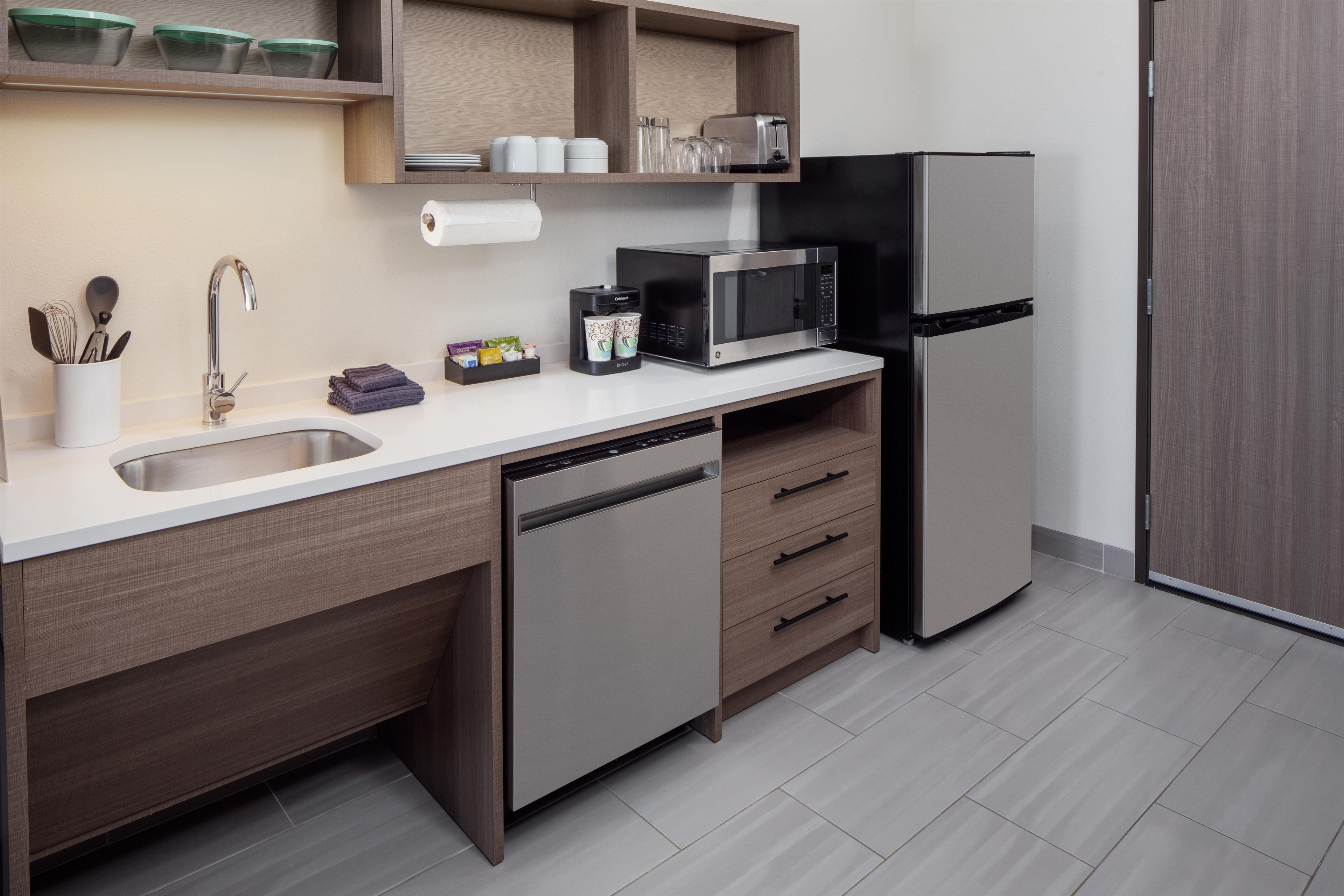 A modern kitchen with a built-in dishwasher, a microwave, and a refrigerator.