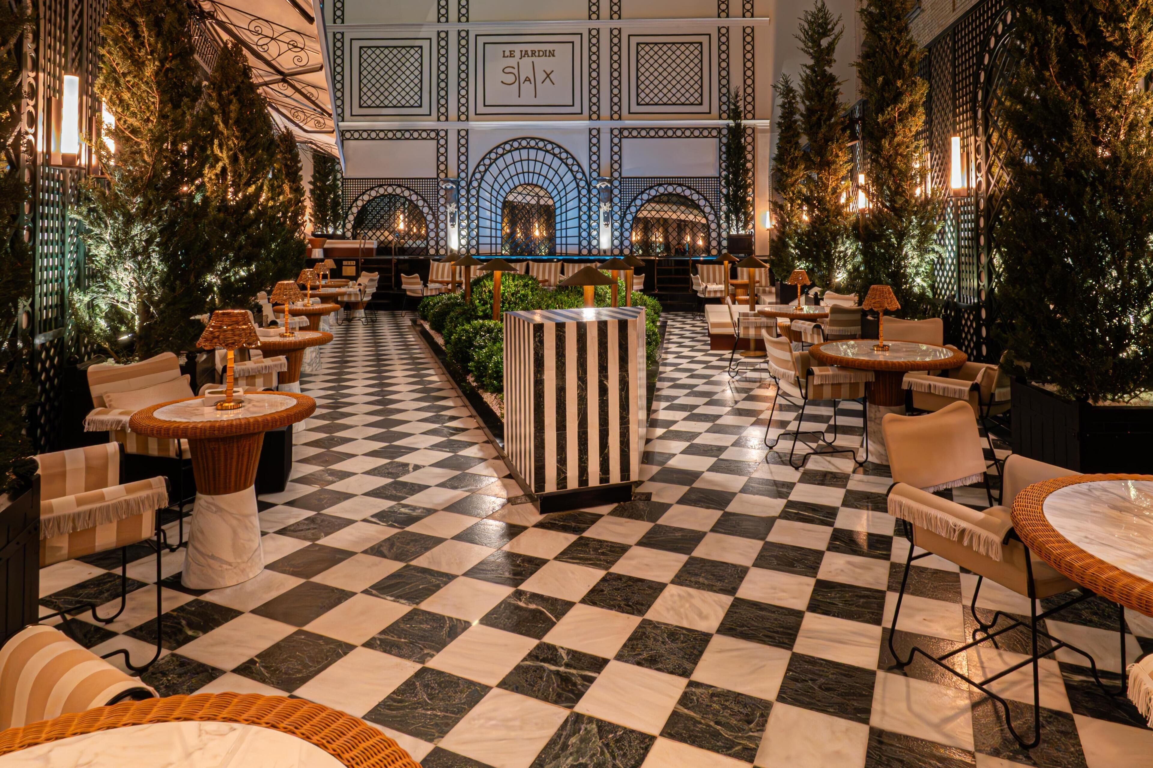 A checkered floor, indoor seating, and a central planter with greenery.