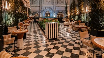 A checkered floor, indoor seating, and a central planter with greenery.