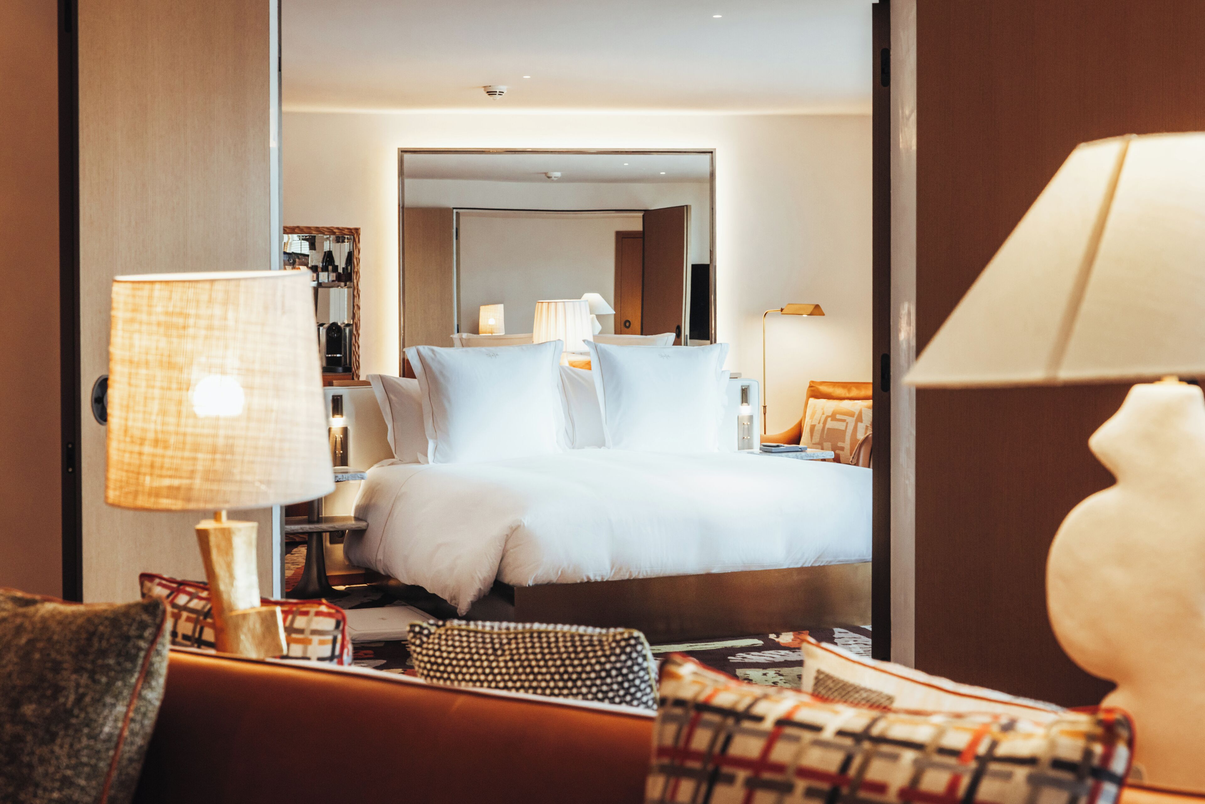 Ein Hotelzimmer mit Bett, einer Couch, einer Lampe und einem Spiegel.