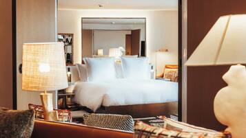 Ein Hotelzimmer mit Bett, einer Couch, einer Lampe und einem Spiegel.