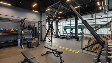 Ein Fitnessstudio mit Gewichten, Laufbändern und Trainingsbällen.