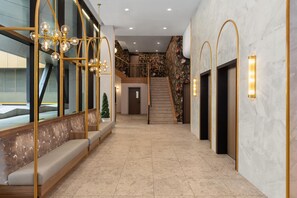 A modern interior with a staircase, seating area, and a decorative wall. - Hampton Inn By Hilton Calgary Downtown (Calgary)