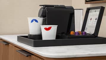 Une machine à café avec des gobelets jetables posée sur un comptoir.
