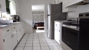 A modern kitchen with white cabinets, a black microwave, a stainless steel refrigerator, and a black stove. - Charming 3-bedroom house with WiFi, and boat parking in peaceful Tiptonville (Tiptonville)
