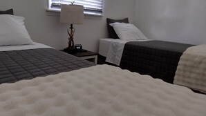 A hotel room with two beds, a nightstand with a lamp, and a window with blinds. - Charming 3-bedroom house with WiFi, and boat parking in peaceful Tiptonville (Tiptonville)