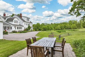 Sit and enjoy the serene surroundings from this outdoor patio with a table and four chairs.