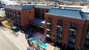 A multi-story hotel with a brick facade, balconies, and a pool area.