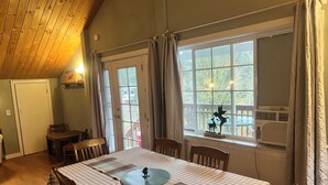 A dining area with a checkered tablecloth, wooden chairs, and a window with curtains. - Washougal River Front Apt. Pets OK
Close to Columbia Gorge, close to PDX (Washougal)